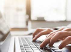 Hands typing on a laptop keyboard