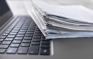 Stack of papers or documents placed on top of a laptop keyboard.