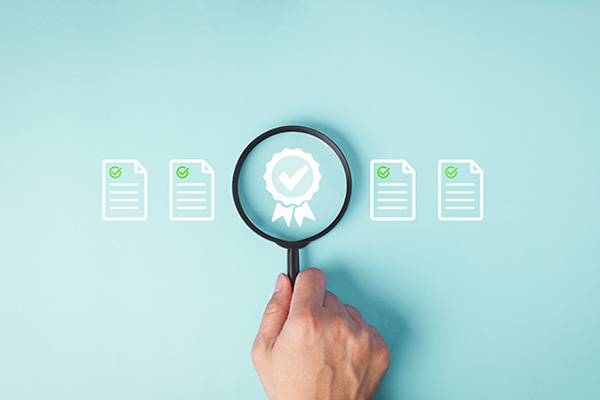 magnifying glass over an award icon surrounded by documents